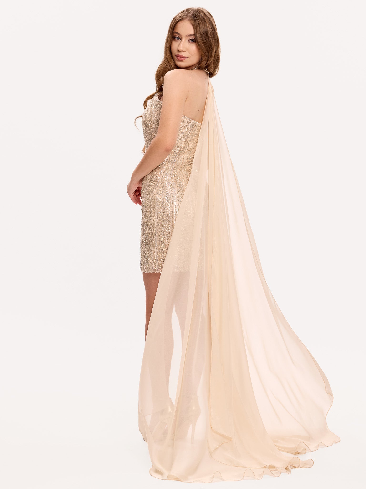 Rochie mini aurie, decorată cu broderie manuală, completată de o capă din mătase care creează un efect fluid în mișcare
