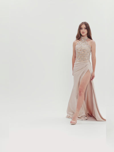Rochie de seară cu corset halter decorat cu cristale și fustă din tafta cu slit adânc, capturată în mișcare pentru a evidenția fluiditatea materialului și eleganța designului.